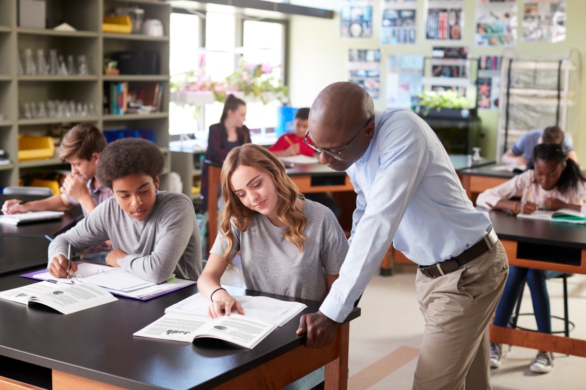 students are sitting in a math class and one female student appears to be ask some differential equation homework help topics doubts form her professor