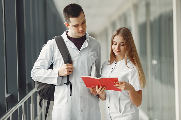 Two medicinal chemistry students in a white coat discussing about their medicinal chemistry homework and assignment