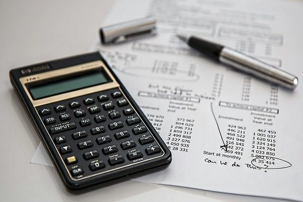 A calculator and pen on a paper with a financial document, indicating budgeting and financial analysis as a part of accounting.