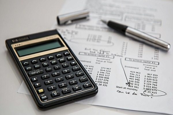 Tools for Financial Analysis: Calculator and Pen A calculator and pen on a paper with a financial document, indicating budgeting and financial analysis as a part of accounting.