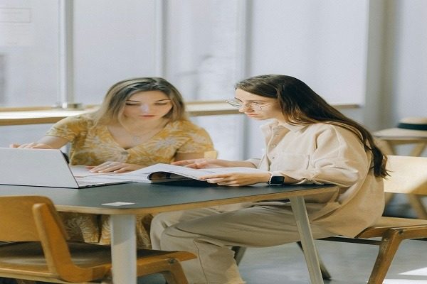 Two female students are having a serious discussion about their computer science homework and assignments.